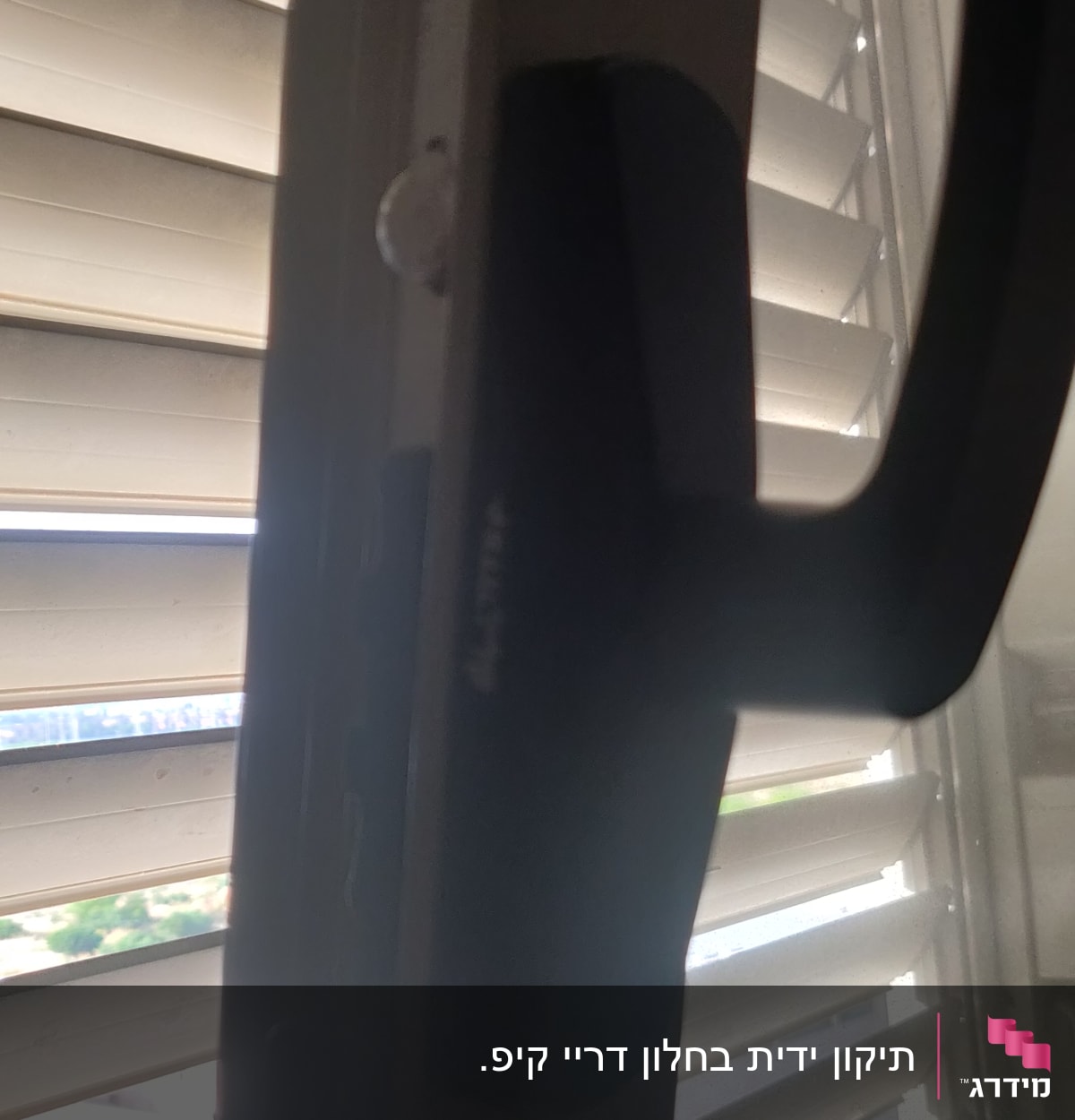 תריסים לבנים עם ידית שחורה על חלון